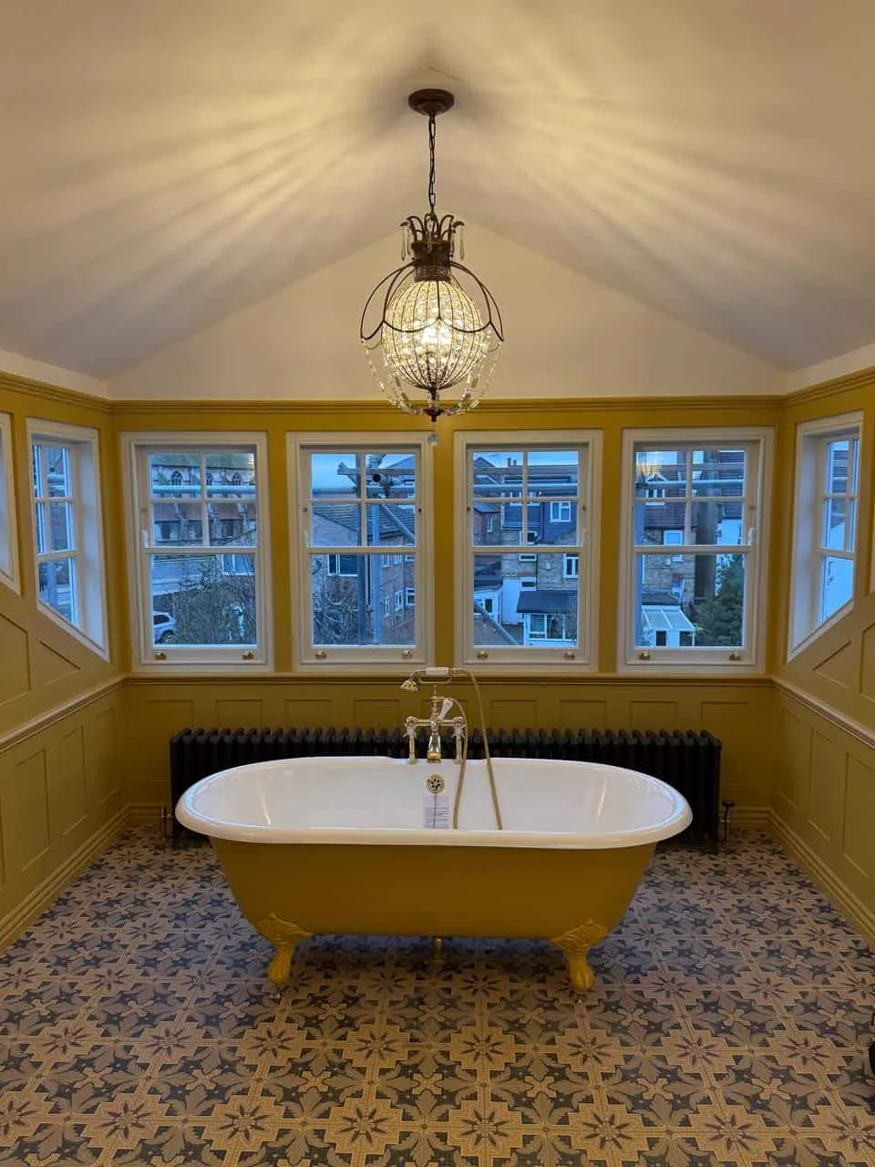 Bathroom with yellow roll-top bath and bay windows