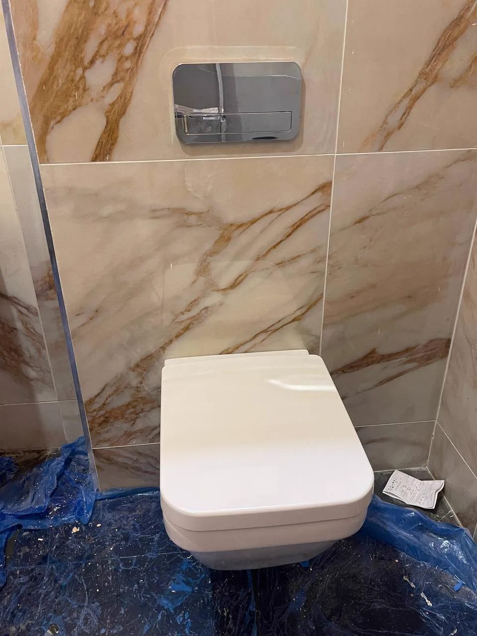 Wall-hung toilet with marble-effect tiles