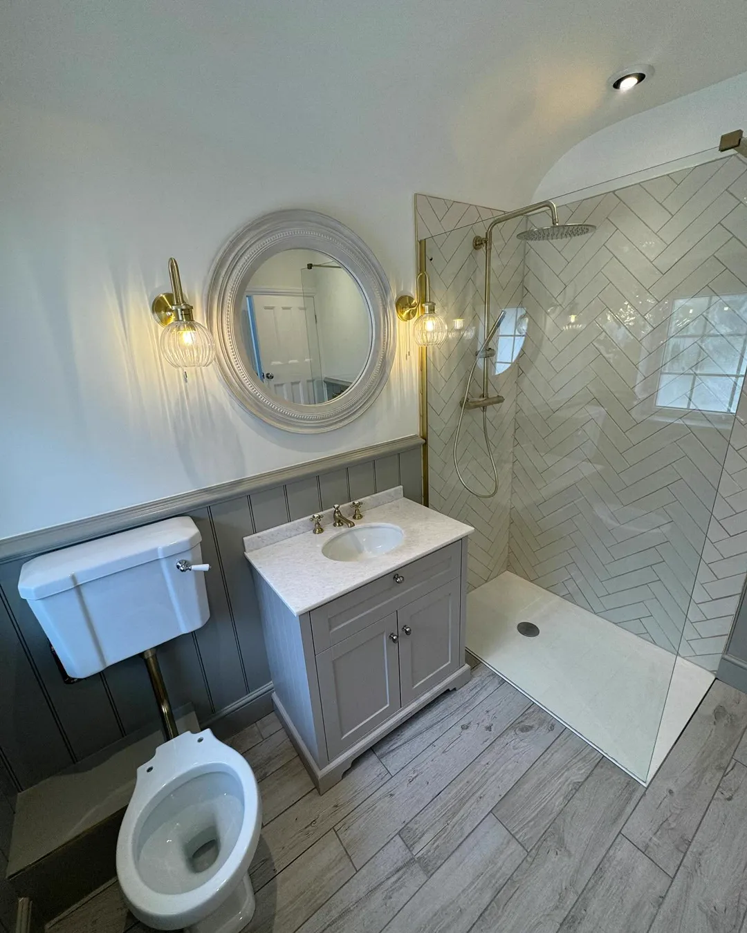Shower room with brass rain shower and herringbone tiles
